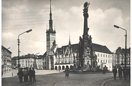 Prakticky tentýž pohled, jen o několik desítek let později. Rok 1965. V té době se ale už náměstí nějakou dobu jmenovalo náměstí Míru. Jeho název se měnil vícekrát. Horní náměstí přejmenovali nejprve na počest prvního prezidenta Masaryka, za války neslo jméno Adolfa Hitlera, pak se na čas vrátil Masaryk, aby ho po Únoru vystřídal Josif Stalin, později diktátorovo jméno vystřídalo náměstí Míru. K názvu Horní se Olomouc vrátila po roce 1989.